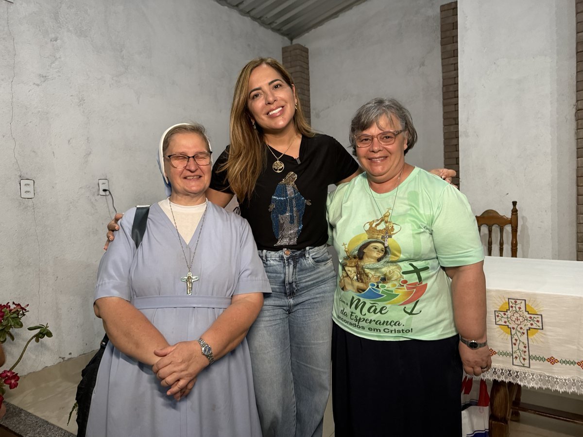 Bete abraçada a uma religiosa e a outra mulher dentro de uma capela
